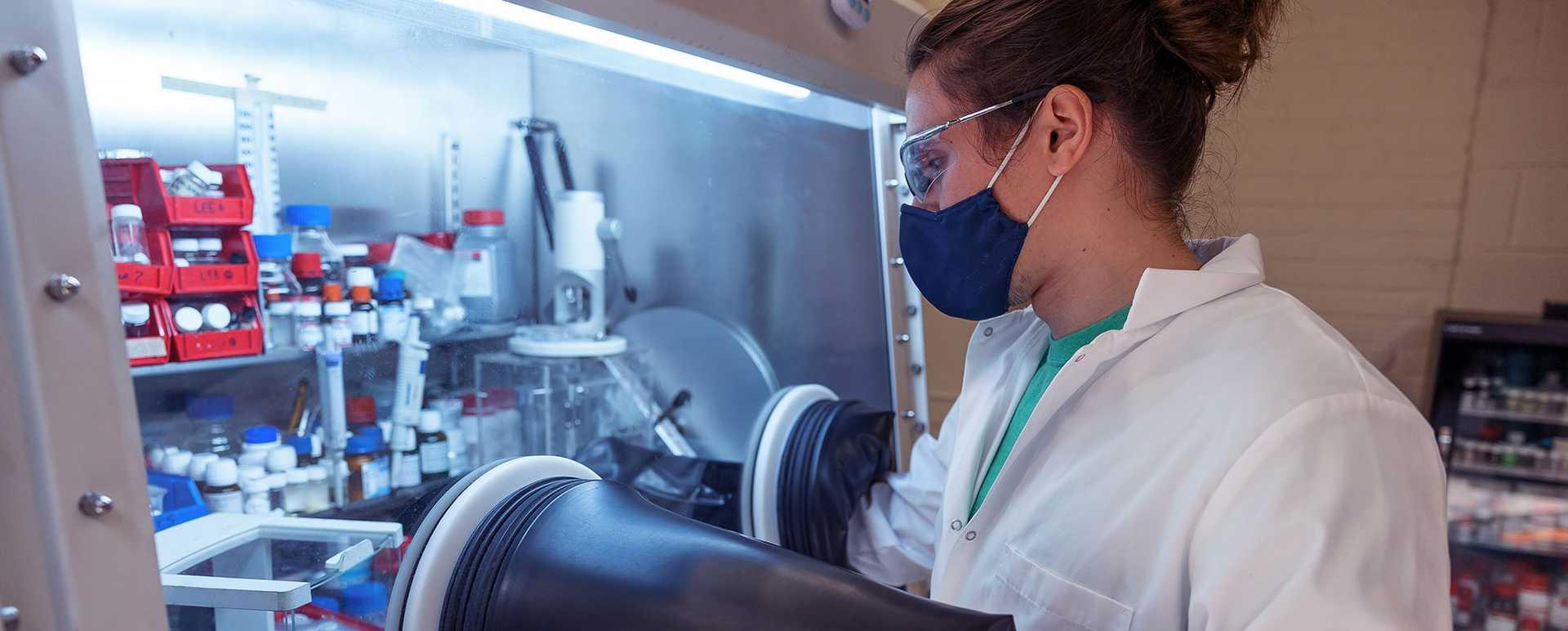 Photo of a Case Western Reserve University student wearing a facemask and goggles, working in a research lab